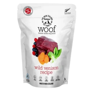 A bag of The New Zealand Natural Pet Food Co. woof freeze-dried wild venison recipe dog food, featuring images of venison, blueberries, carrots, and bok choy.
