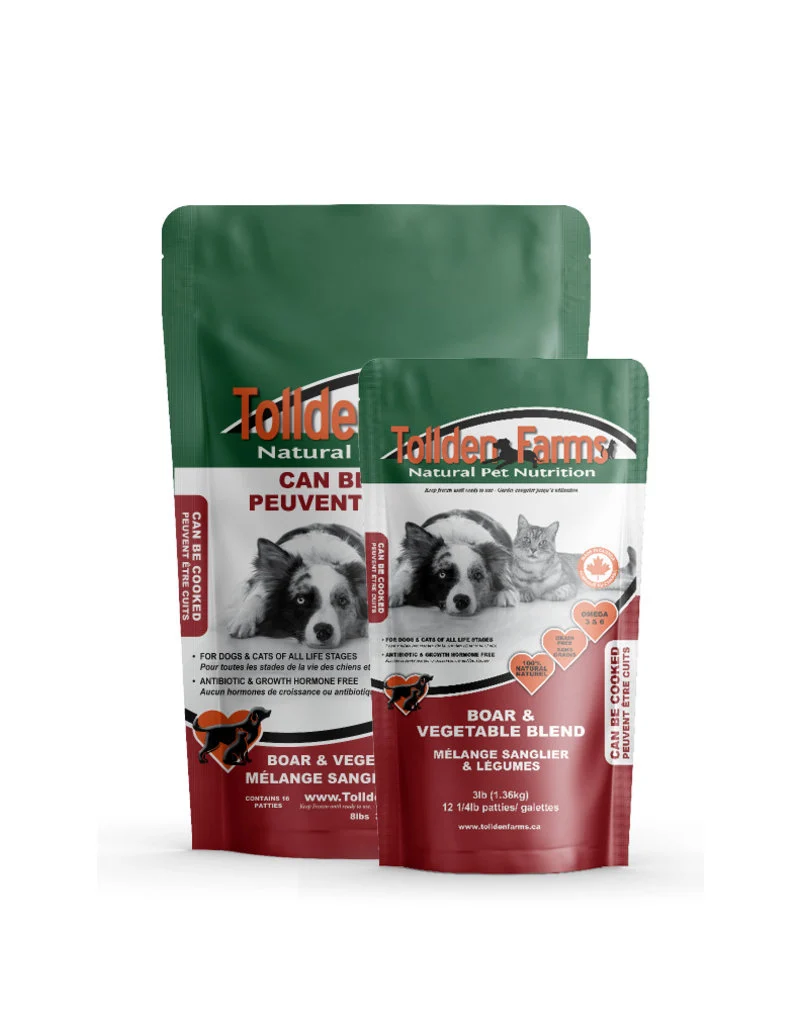 Two packages of Tollden Farms pet food, labeled "Boar & Vegetable Blend." The larger bag features images of a dog and a cat and text highlighting its suitability for all life stages. Both bags are green and red.