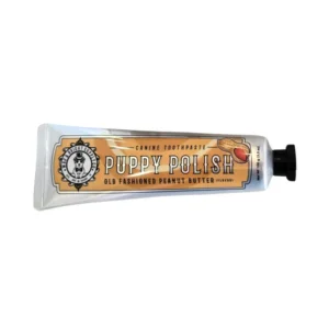A tube labeled "Puppy Polish Canine Toothpaste, Old Fashioned Peanut Butter Flavor" with a peanut image and a black cap, designed for dog dental care.